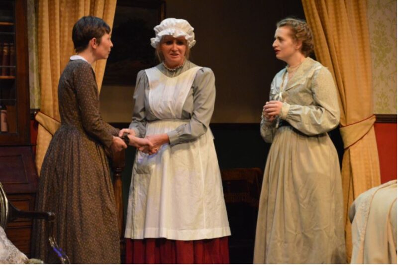 A photograph from the Little Women production of April 2019 showing (L to R) Becci Dixon as Jo March, Jude Downing as Hannah and Kathryn Sergison as Meg March